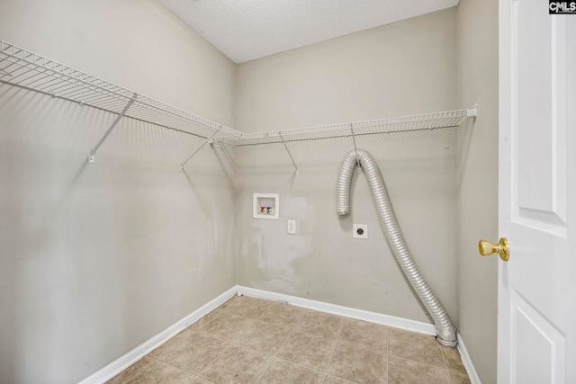 laundry room featuring hookup for a washing machine, a textured ceiling, light tile patterned floors, and electric dryer hookup