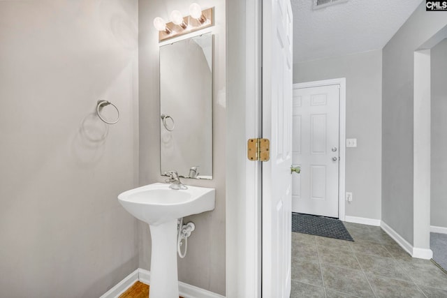 bathroom featuring a textured ceiling and tile patterned floors