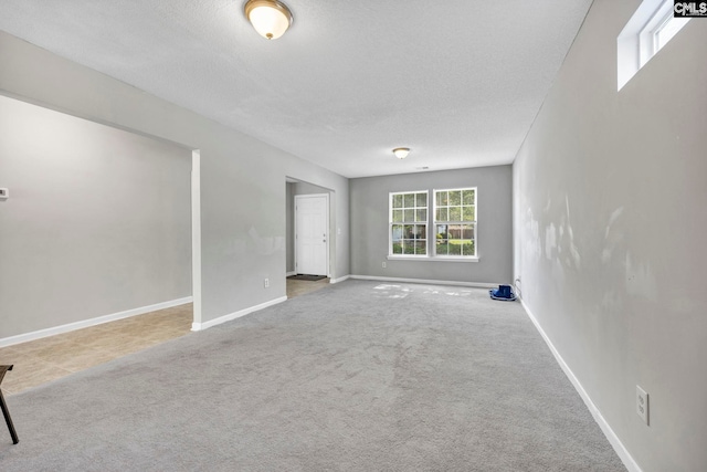 carpeted empty room with a textured ceiling