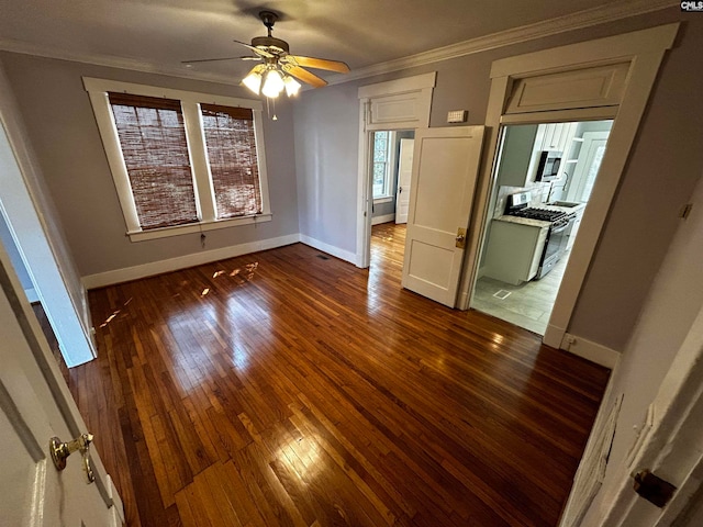 unfurnished bedroom featuring ceiling fan, dark wood-type flooring, and crown molding