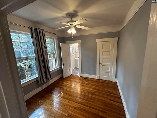 unfurnished bedroom with connected bathroom, ceiling fan, and dark hardwood / wood-style flooring