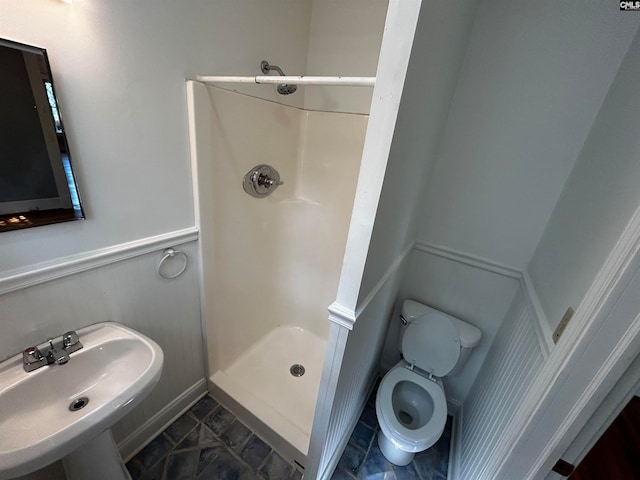 bathroom featuring sink, walk in shower, and toilet