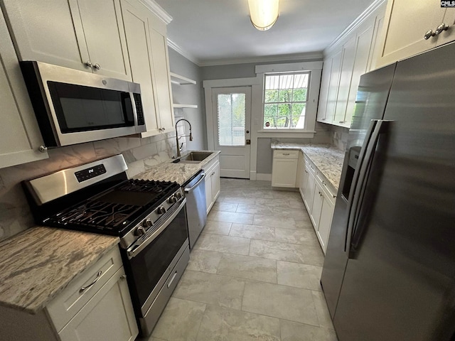 kitchen featuring light stone countertops, stainless steel appliances, white cabinetry, and sink