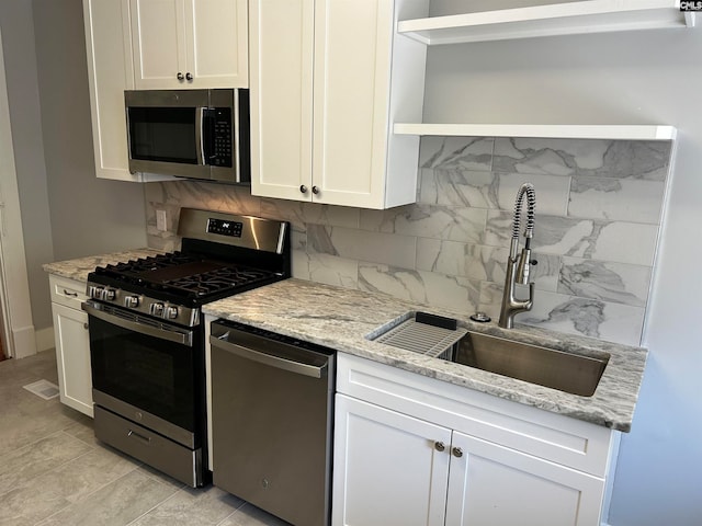 kitchen featuring appliances with stainless steel finishes, backsplash, white cabinetry, and sink