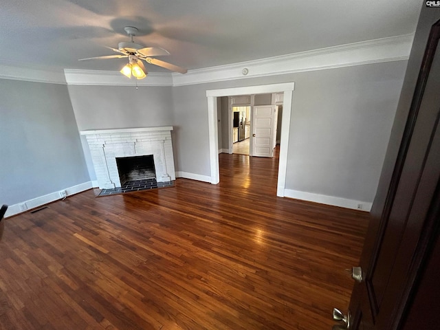 unfurnished living room featuring ornamental molding, ceiling fan, a fireplace, and dark wood-type flooring