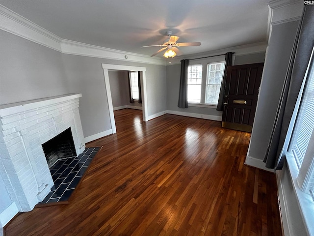 unfurnished living room with ornamental molding, dark hardwood / wood-style floors, ceiling fan, and a brick fireplace