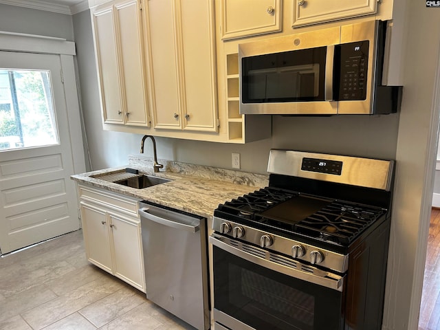 kitchen featuring light stone counters, light hardwood / wood-style floors, sink, stainless steel appliances, and ornamental molding