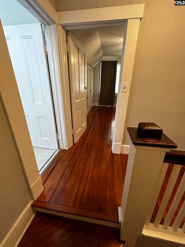 hall featuring vaulted ceiling and dark hardwood / wood-style flooring