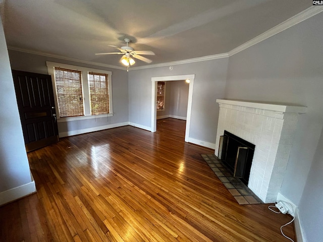 unfurnished living room featuring ceiling fan, a brick fireplace, dark hardwood / wood-style flooring, and crown molding