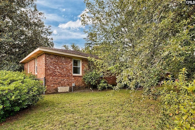 view of property exterior with a lawn and brick siding