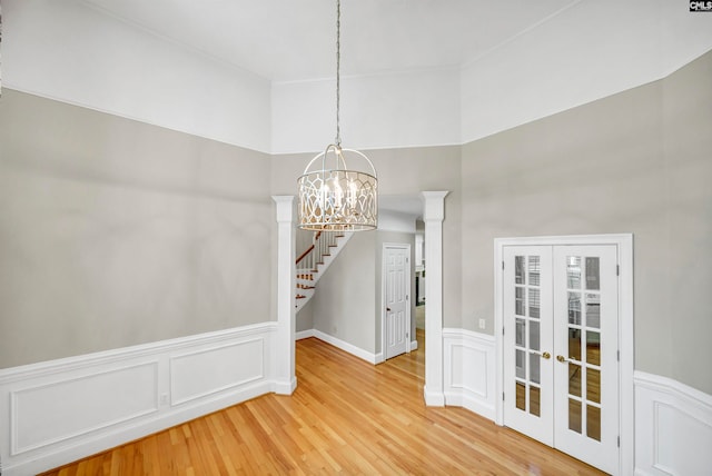 unfurnished dining area featuring a notable chandelier and hardwood / wood-style flooring