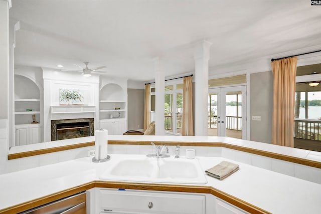 kitchen with white cabinets, a wealth of natural light, a fireplace, and sink