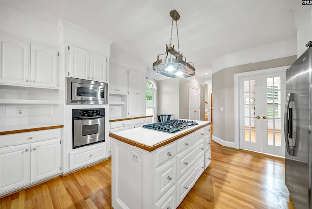 kitchen with appliances with stainless steel finishes, white cabinetry, and a wealth of natural light