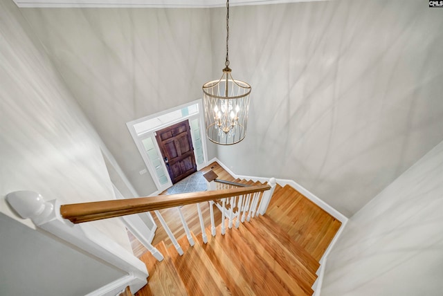 staircase with a chandelier and hardwood / wood-style floors