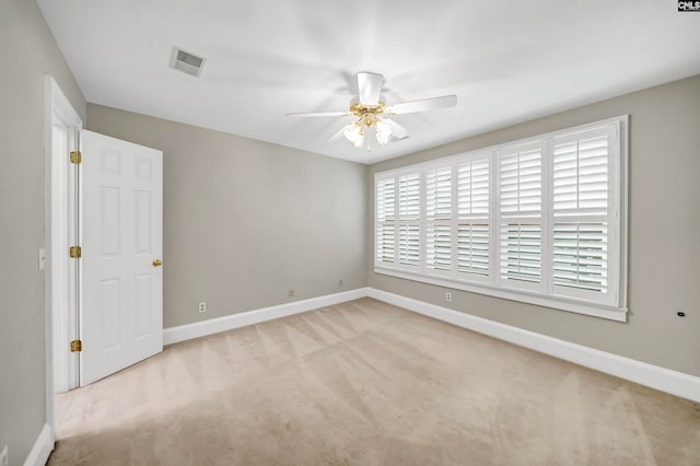 spare room featuring ceiling fan and light colored carpet