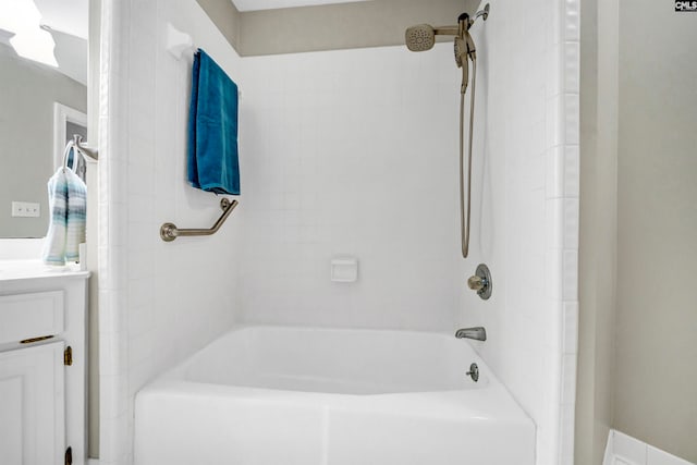 bathroom featuring tiled shower / bath combo and vanity