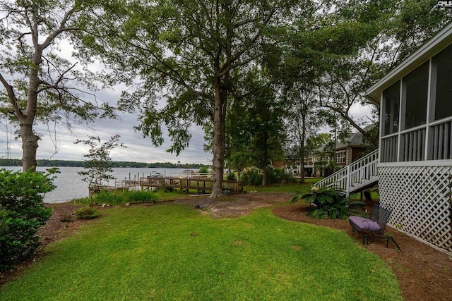 view of yard with a water view and a sunroom