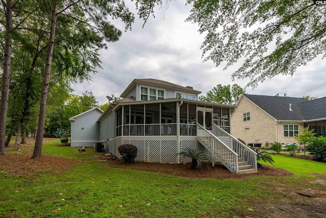 rear view of property with a sunroom and a lawn