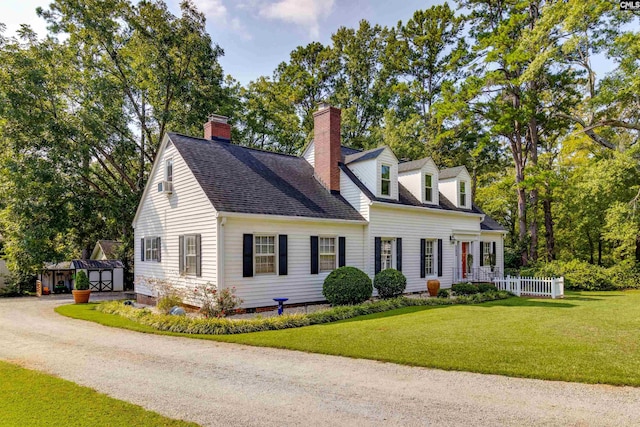 cape cod house featuring a front lawn