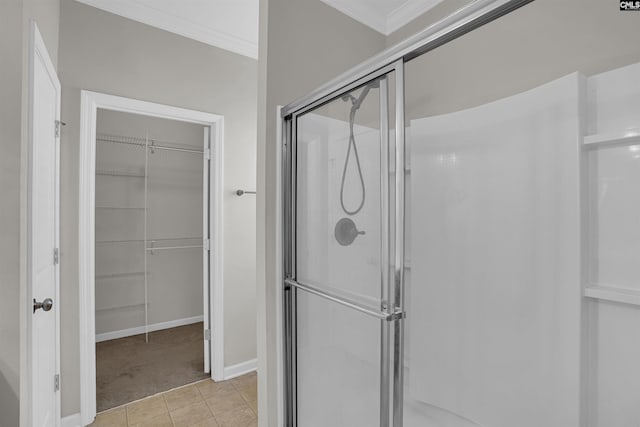 bathroom featuring tile patterned flooring, a shower with shower door, and crown molding