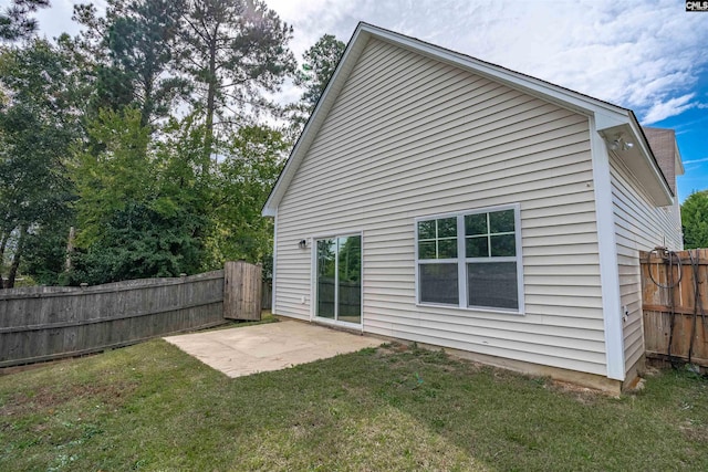 back of house featuring a lawn and a patio area