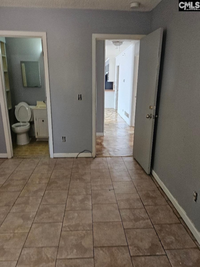 interior space with a textured ceiling and light tile patterned floors