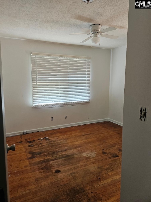 unfurnished room featuring ceiling fan, a textured ceiling, and dark hardwood / wood-style flooring