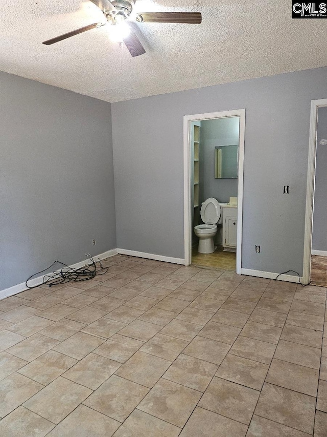 unfurnished room featuring a textured ceiling, light tile patterned floors, and ceiling fan