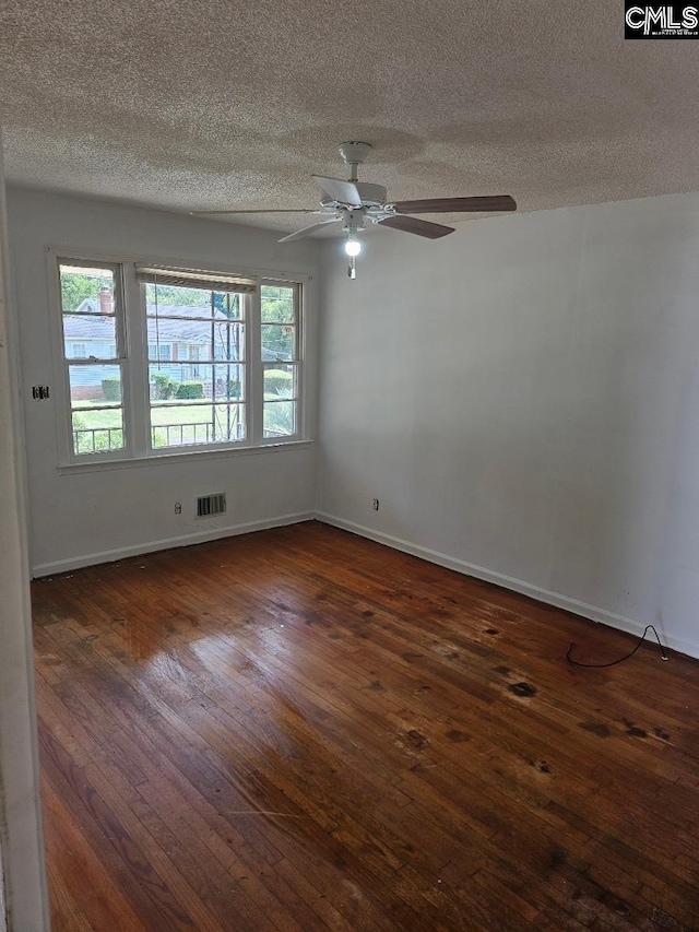 unfurnished room with ceiling fan, a textured ceiling, and dark hardwood / wood-style floors