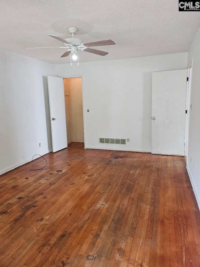 spare room with a textured ceiling, wood-type flooring, and ceiling fan