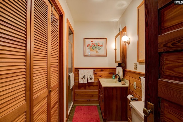 bathroom featuring tile patterned floors, a shower with door, vanity, and toilet