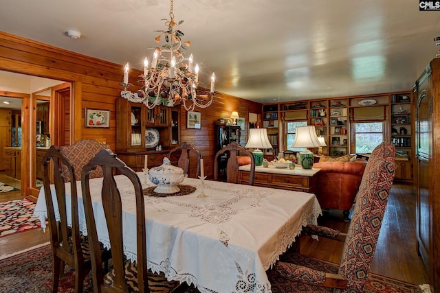 dining space featuring an inviting chandelier, dark hardwood / wood-style floors, and wood walls