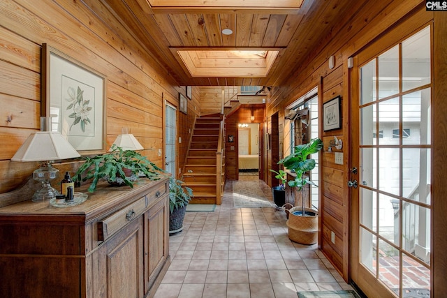 corridor featuring a skylight, wood walls, and a healthy amount of sunlight