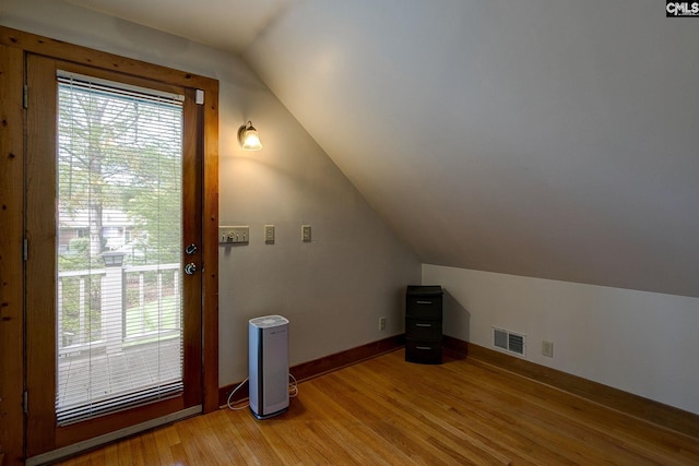 bonus room featuring wood-type flooring and vaulted ceiling