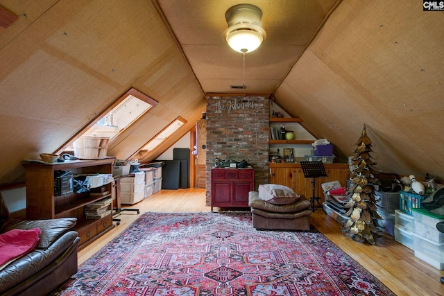 bonus room featuring vaulted ceiling with skylight and light hardwood / wood-style floors