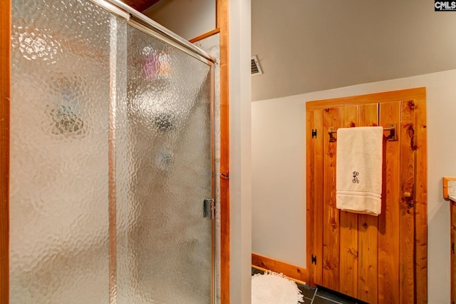 bathroom featuring lofted ceiling and a shower with door