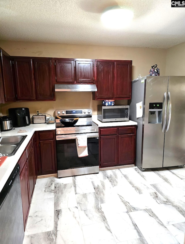 kitchen featuring appliances with stainless steel finishes, a textured ceiling, and sink