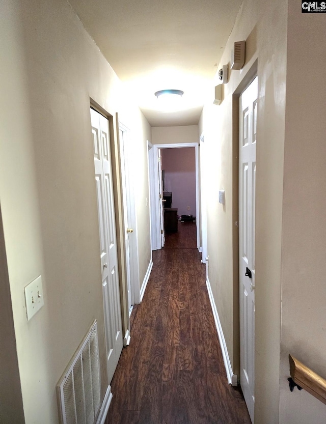 corridor with dark hardwood / wood-style flooring