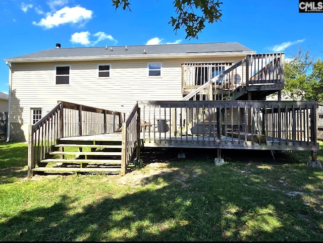 rear view of house with a wooden deck and a lawn