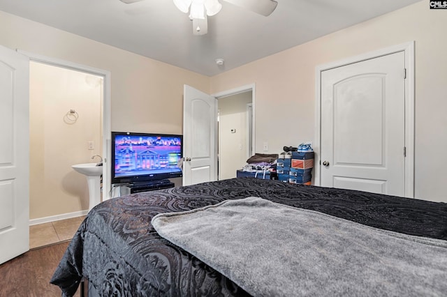 bedroom featuring wood-type flooring, ceiling fan, ensuite bathroom, and sink