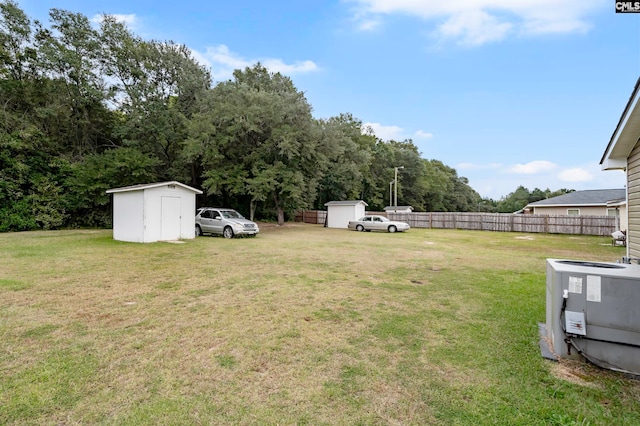 view of yard featuring a storage shed and central air condition unit