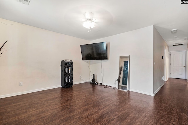 unfurnished living room featuring ceiling fan and dark wood-type flooring