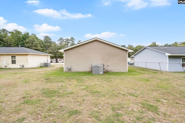 back of property with a lawn and central AC