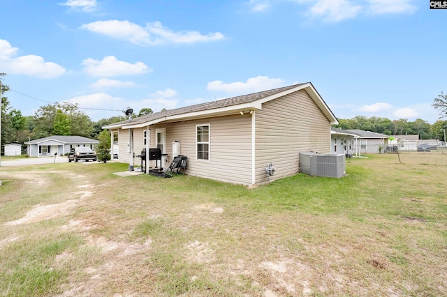 view of side of property featuring cooling unit and a yard