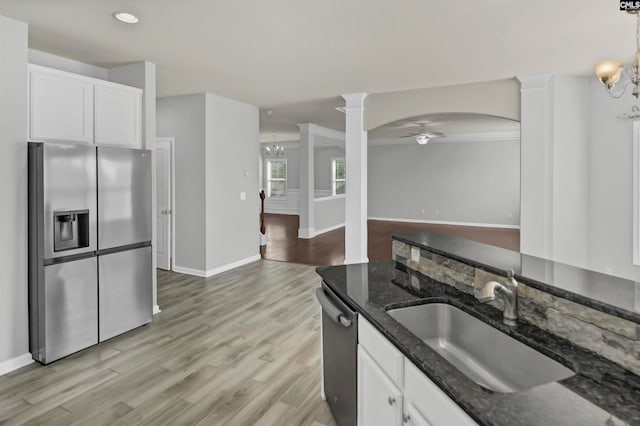 kitchen featuring ornate columns, sink, stainless steel appliances, and white cabinets