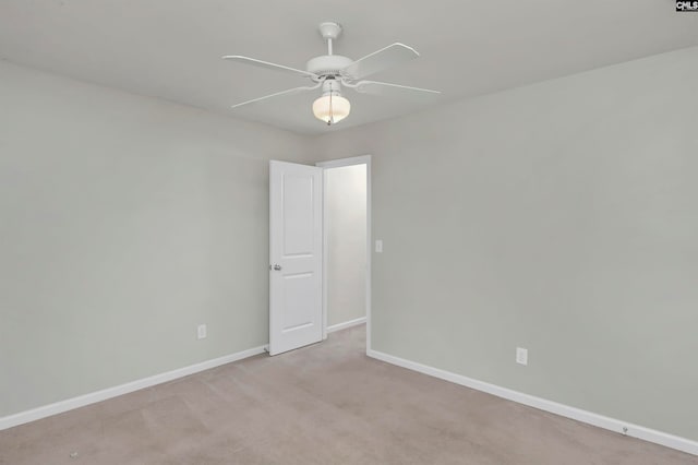 spare room with ceiling fan and light colored carpet