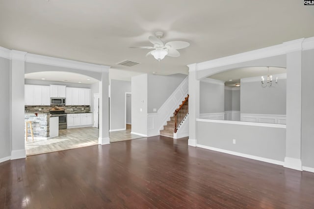 unfurnished living room featuring ceiling fan with notable chandelier, hardwood / wood-style floors, and crown molding