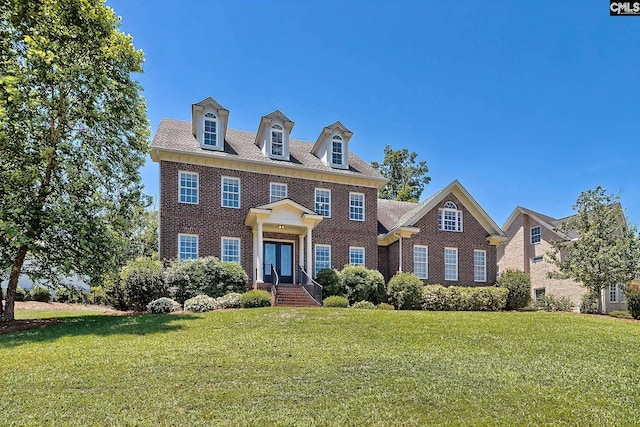 colonial-style house featuring a front yard