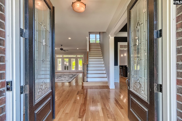 entryway with brick wall, ceiling fan, light hardwood / wood-style flooring, french doors, and ornamental molding