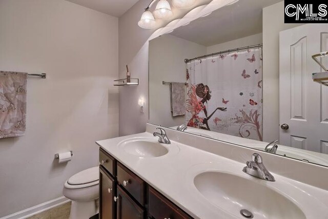 bathroom with walk in shower, vanity, tile patterned floors, and toilet